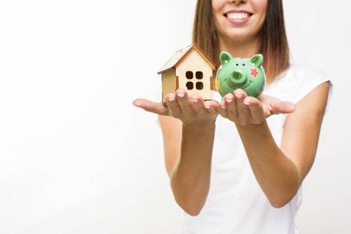 smiley-woman-holding-wooden-cottage-piggy-back