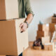 Close-up of a man with carton boxes moving into new home.